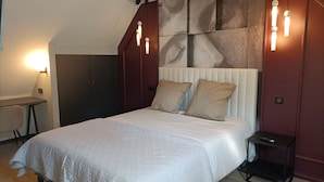 Ein modernes Schlafzimmer mit einem großen Bett, einem Schreibtisch und einem Stuhl.