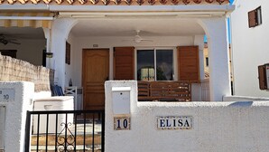 Una casa de dos pisos con un balcón, una reja y un letrero que dice "ELISA".