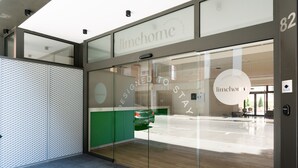 A modern building entrance with a glass door, a sign reading "limehome", and a view of the street outside. - Limehome Barcelona Carrer de Besalú 82 (Barcelona)