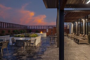 Un espace extérieur aménagé avec une terrasse, des sièges et un foyer.