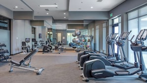 A modern gym with various cardio machines, weightlifting equipment, and a mirror wall. - Courtyard by Marriott Conway (Conway)