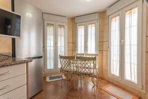 A kitchen with a dining table, chairs, and a TV.