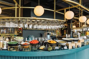 A buffet setup with various food items and glassware.