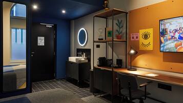 Een moderne hotelkamer met een bureau, stoel en een groot scherm waarop een video wordt afgespeeld.