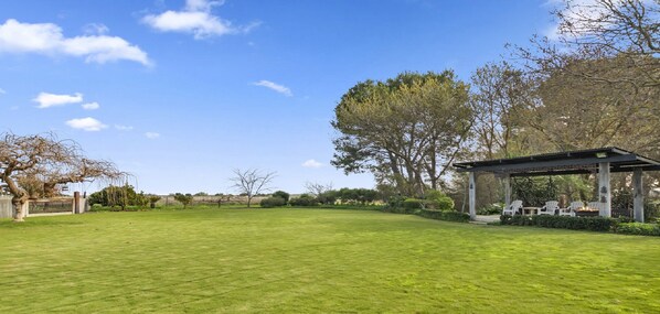 A spacious lawn with a gazebo and outdoor seating area. - The Cubby House by Wine Coast Holiday Rentals (WHITES VALLEY)