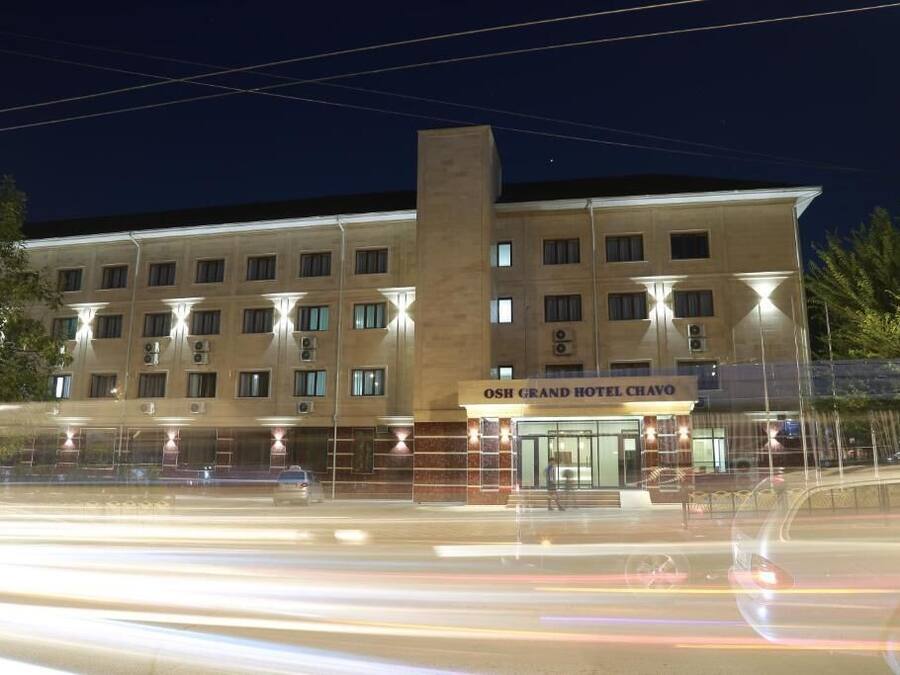 A multi-story hotel with a prominent entrance and illuminated windows.