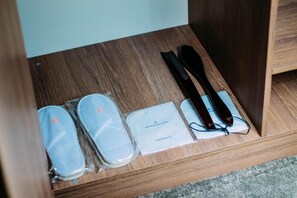 Un cajón de madera con zapatillas, un par de gafas y un pequeño folleto.