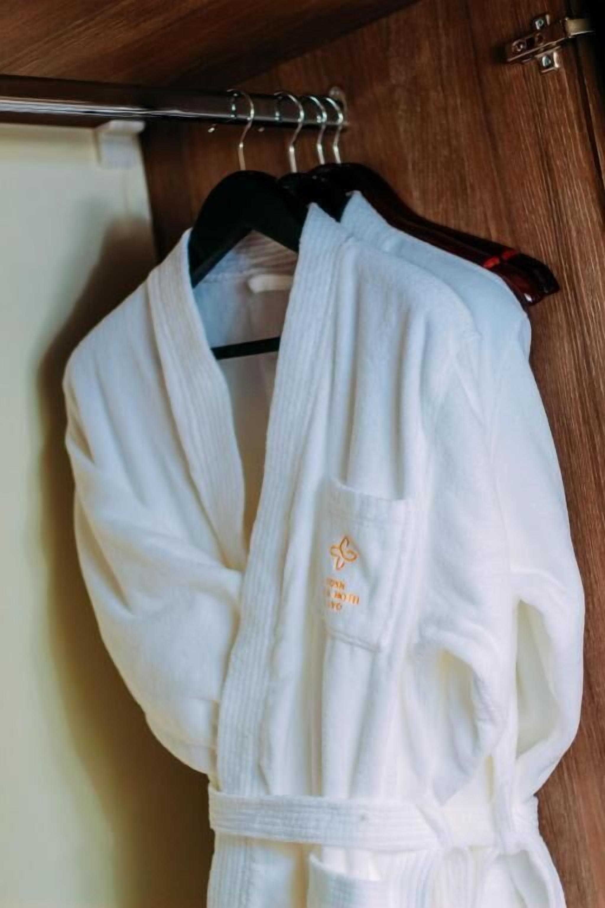 A white bathrobe hanging on a wooden door.
