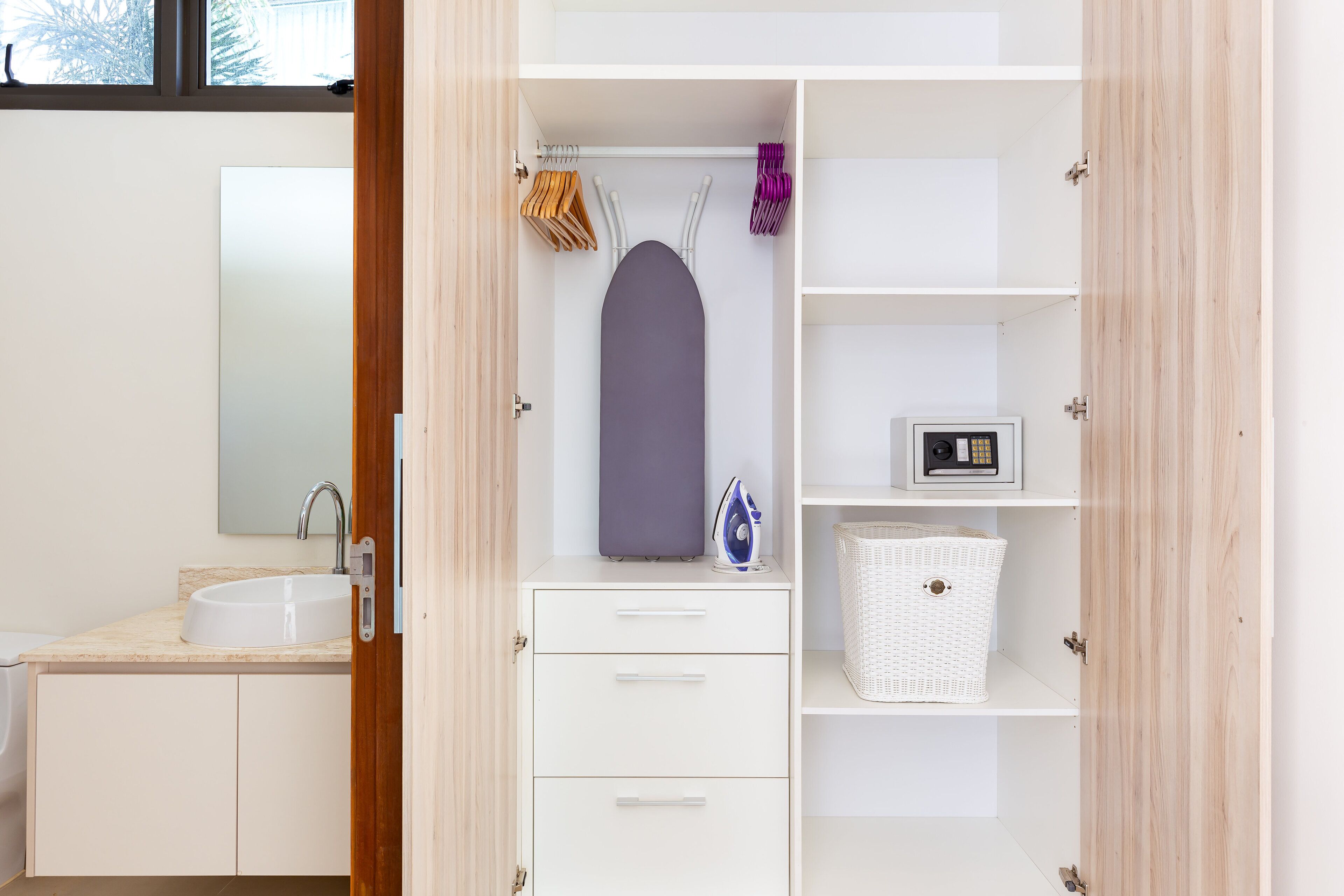 A modern bathroom with a sink, mirror, and storage cabinets.