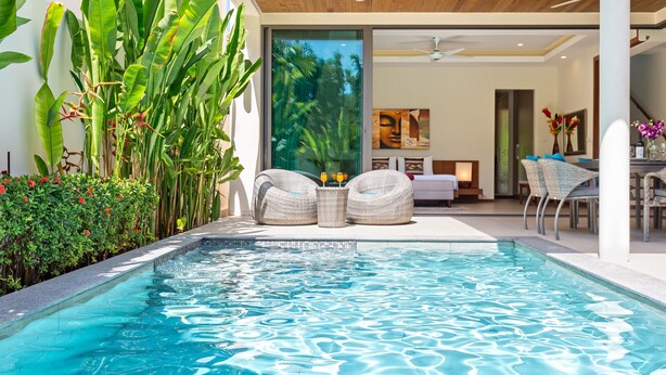 A modern pool area with a glass enclosure, wicker seating, and a view of the interior. - Two Storey Villa Kael in KA Villas Rawai (Rawai)