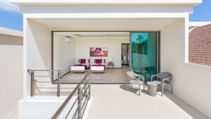 A modern hotel room with a balcony, two beds, a large window, and a view of the sky. - Two Storey Villa Kael in KA Villas Rawai (Rawai)