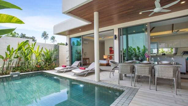 A modern outdoor pool area with lounge chairs, a dining table, and a ceiling fan. - Trendy 4BR Villa Kari in KA Villas Rawai (Rawai)