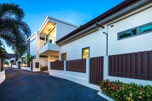 A modern residential building with a two-story structure, a balcony, and a gated driveway. - Trendy 4BR Villa Kari in KA Villas Rawai (Rawai)