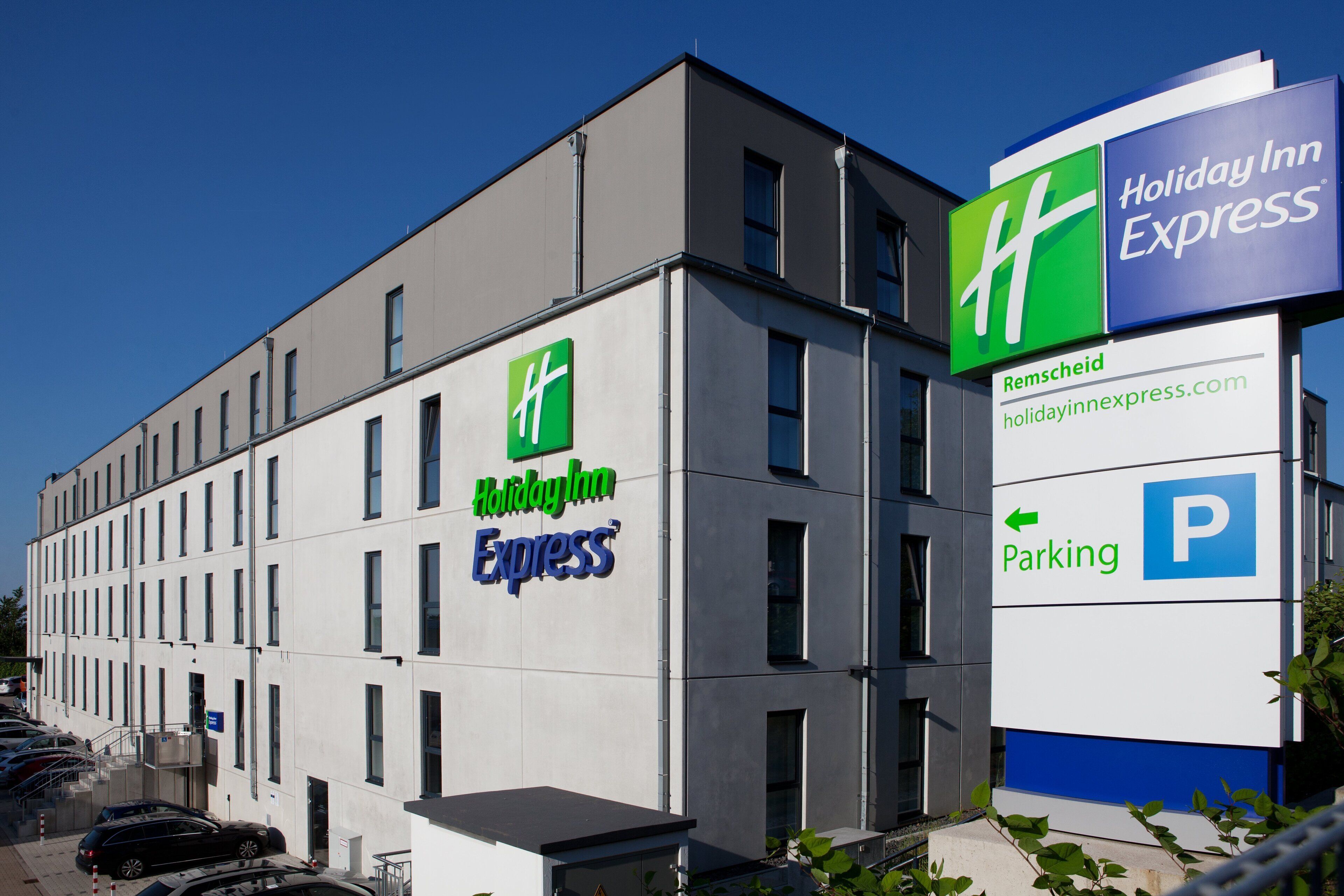 Ein Holiday Inn Express Gebäude mit einem deutlichen Schild, das einen Parkplatz kennzeichnet.