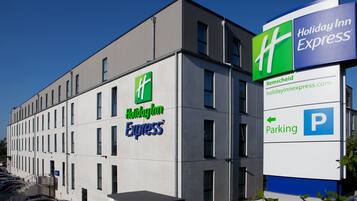 Ein Holiday Inn Express Gebäude mit einem deutlichen Schild, das einen Parkplatz kennzeichnet.