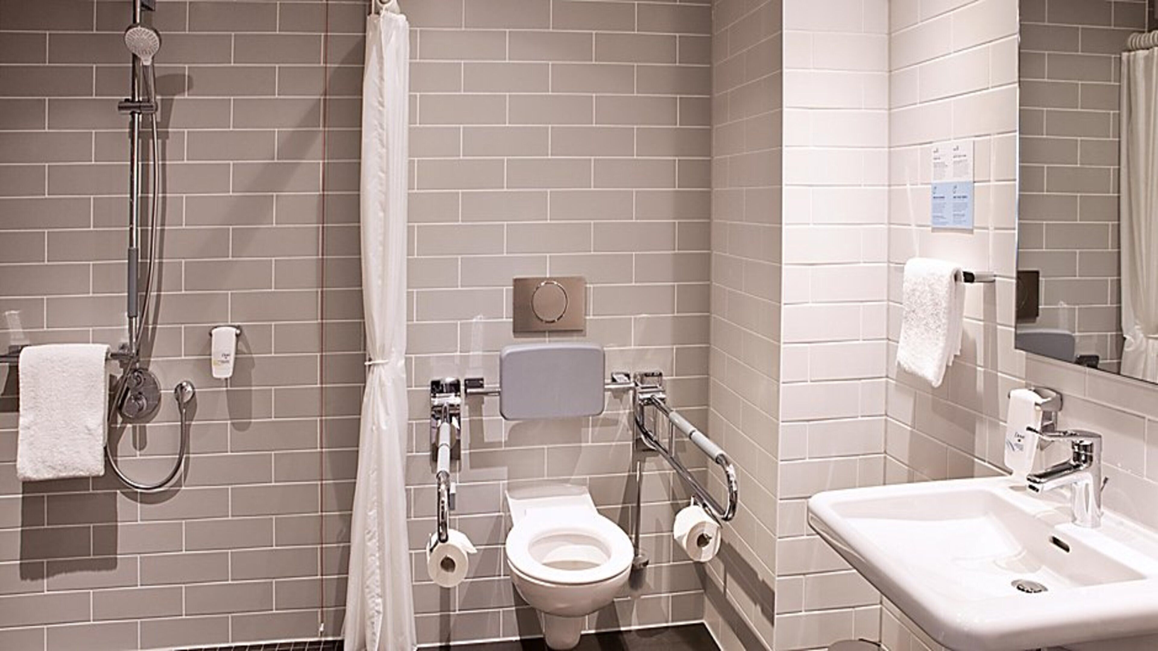 A bathroom with a shower, toilet, and sink.