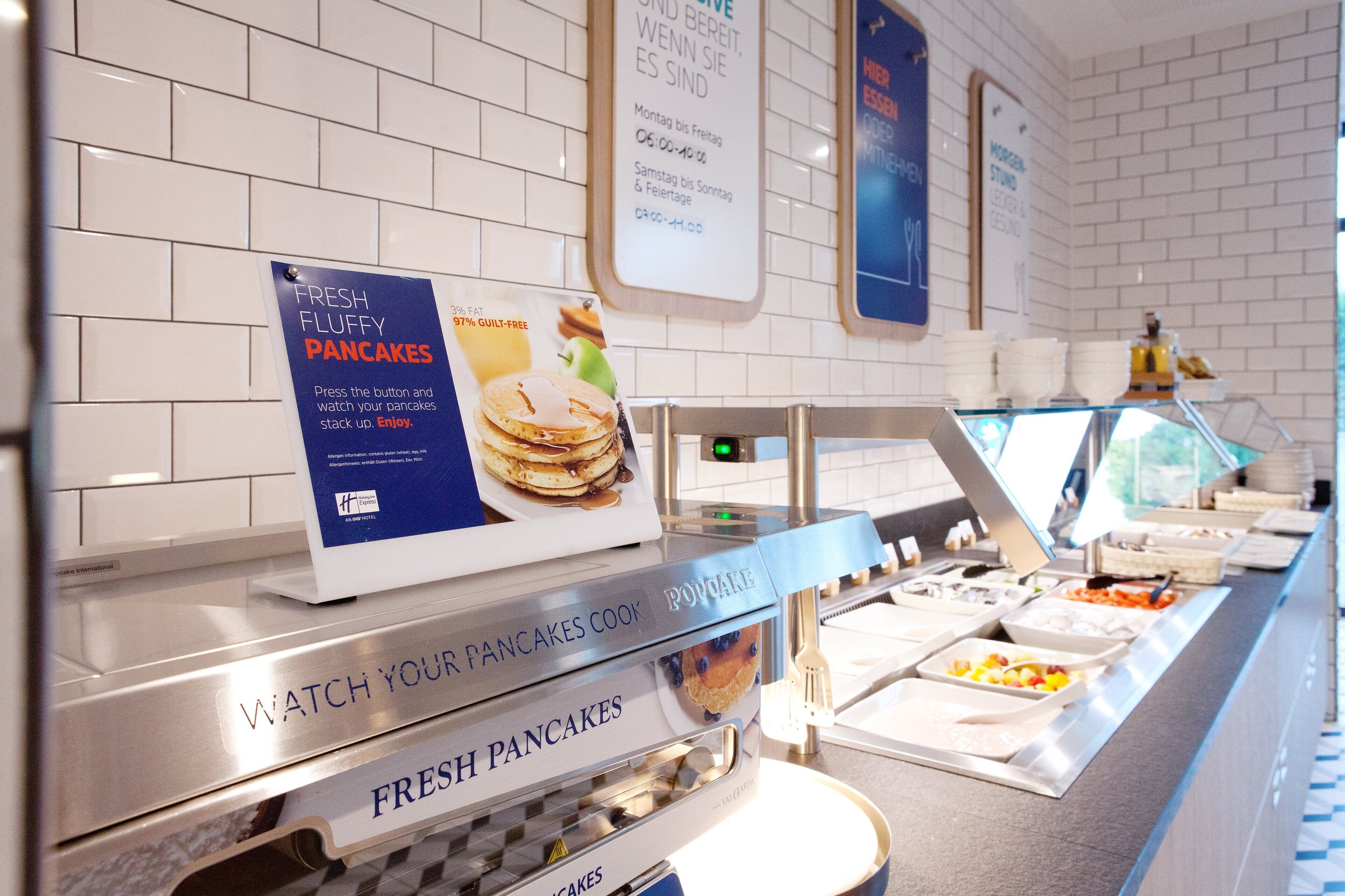 Ein Bereich für das Frühstücksbuffet mit einem Schild, das frische, lockere Pfannkuchen anwirbt.
