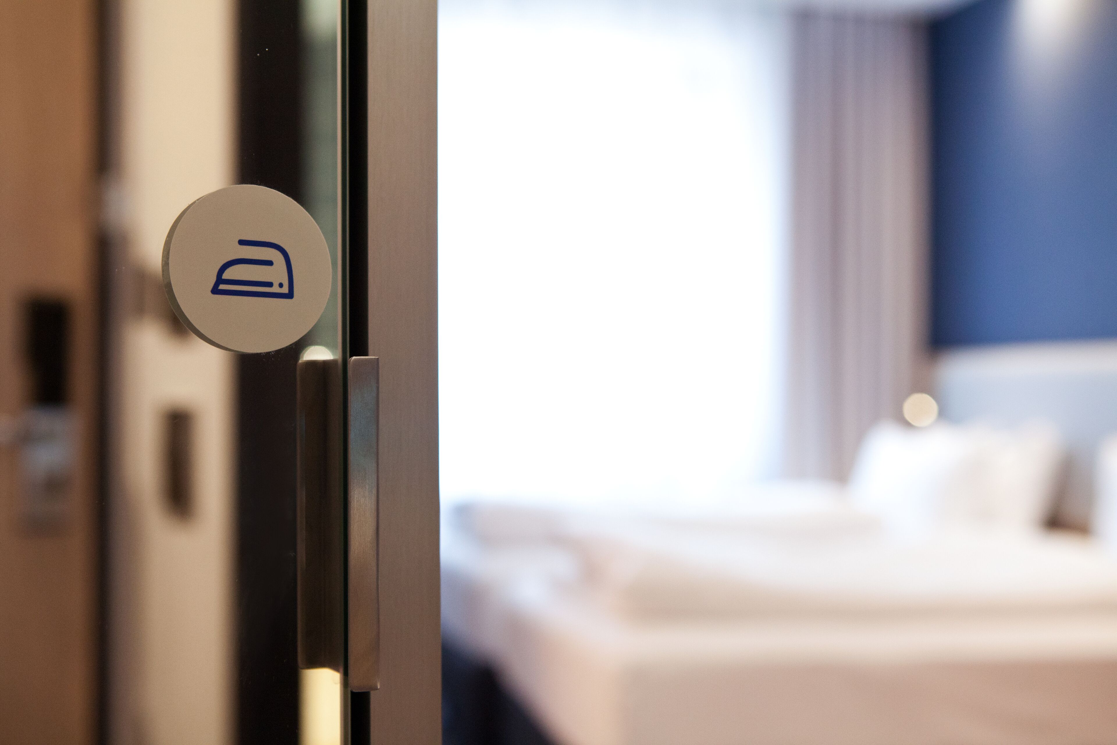Una habitación de hotel con una cama, una puerta con el icono de una habitación y vistas a otro dormitorio.
