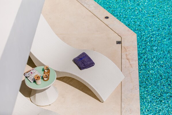 A poolside area with lounge chairs, a small table with a magazine, and a towel. - Villa The Wave 2 Residence (Koh Samui)