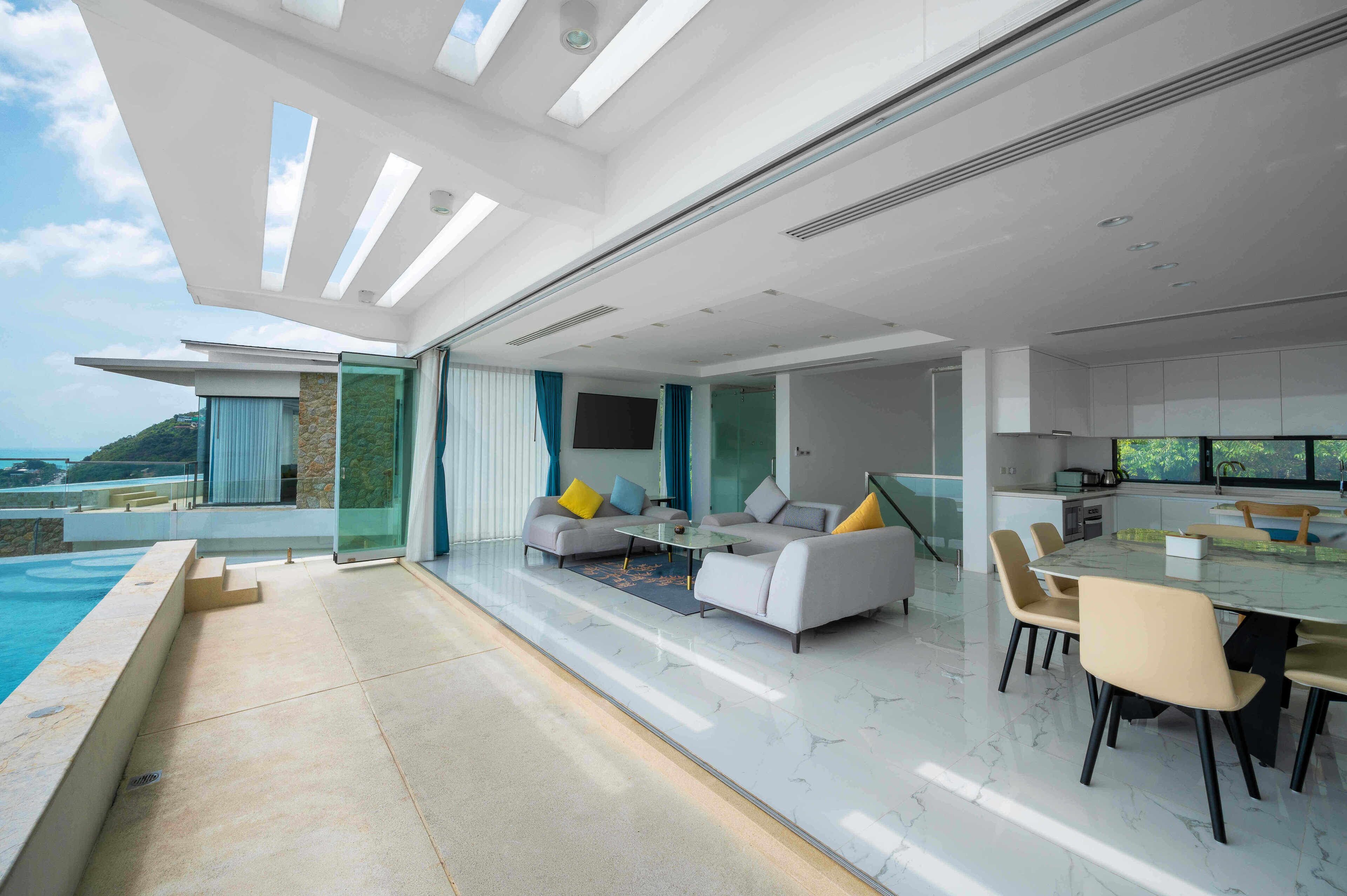 A modern living space with a pool, seating area, and dining setup.