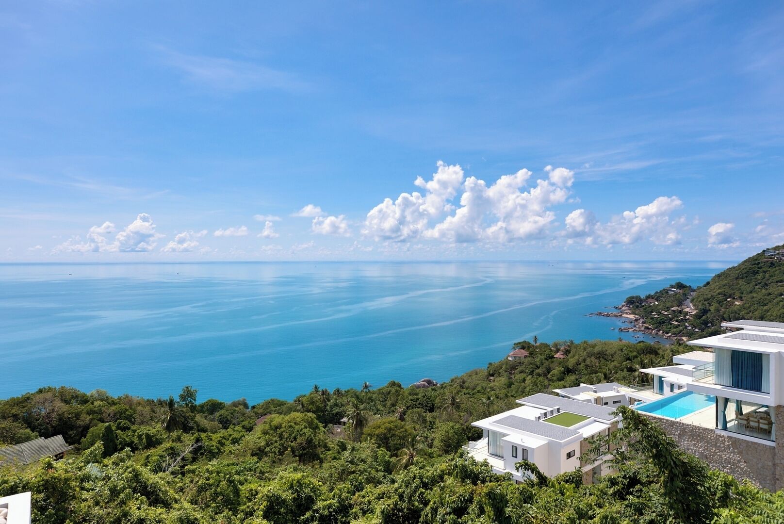 A coastal property with modern architecture, a swimming pool, and a view of the sea.