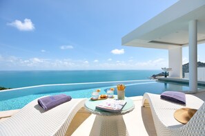 A luxurious outdoor seating area with a view of the ocean, a pool, and a modern architectural design. - Villa The Wave 2 Residence (Koh Samui)