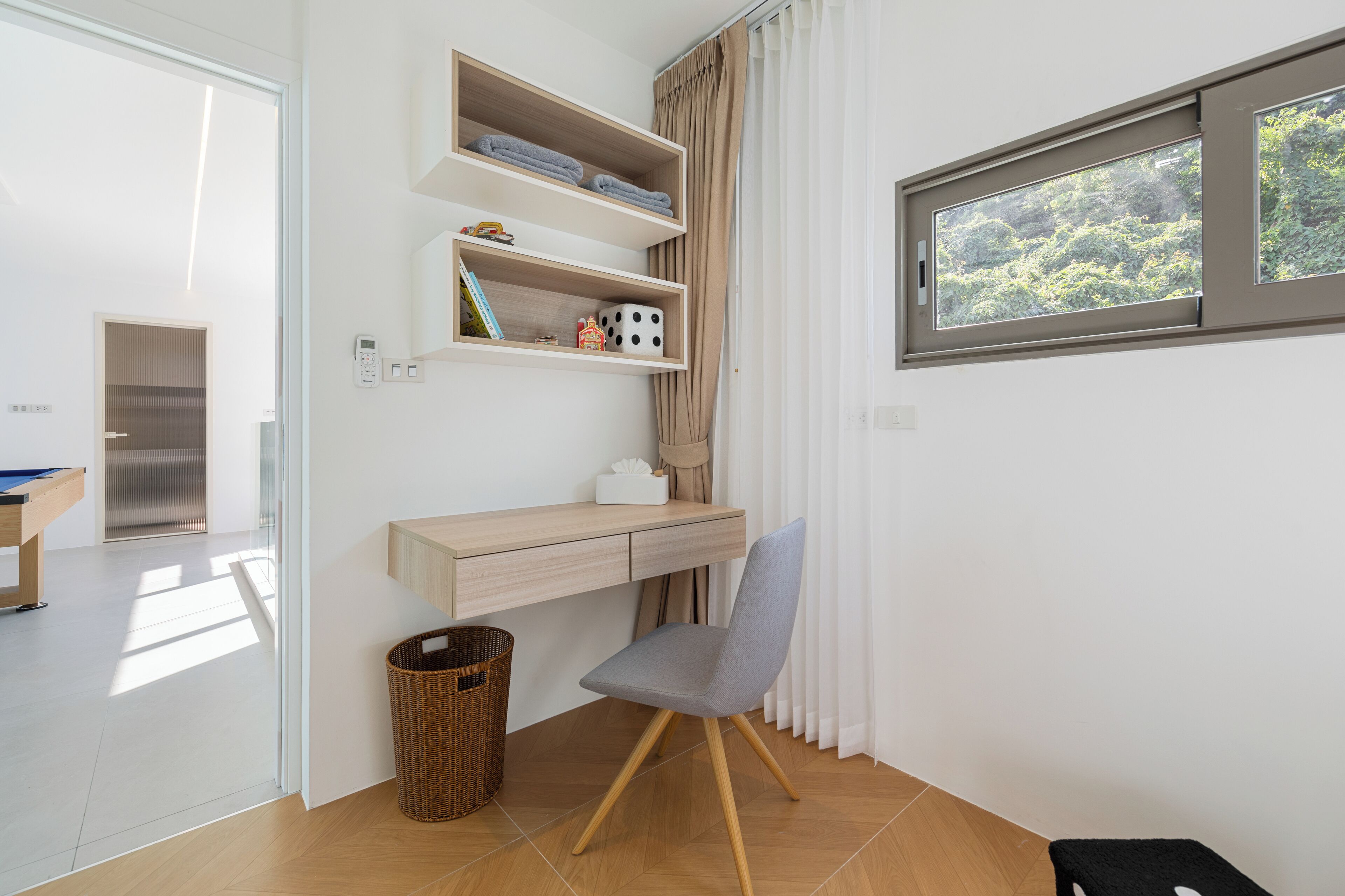 Una habitación moderna con escritorio, estanterías, una silla, una ventana y una puerta.