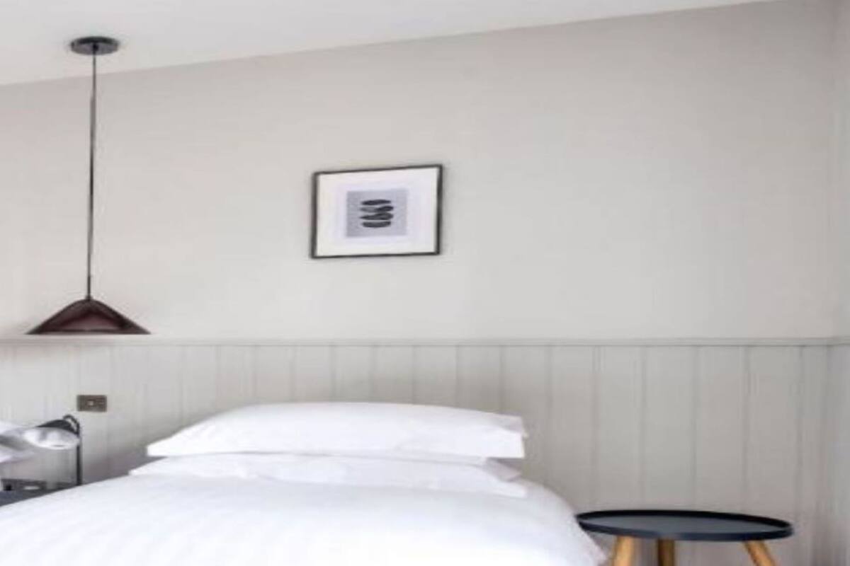 A bedroom with a bed, bedside table, and a small round table.