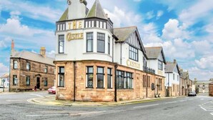 A traditional building with "The Castle" sign, featuring a corner tower and large windows. - The Castle Hotel (Berwick-upon-Tweed)