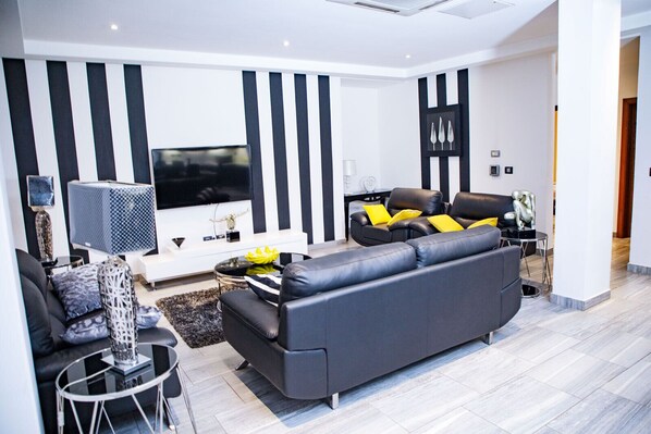 Relax in this stylish living room with a large sofa, flat-screen TV, and modern coffee table.