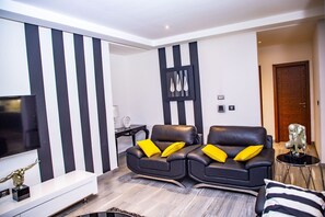 Relax in this stylish living room with a flat-screen TV, two comfortable sofas, and a side table.