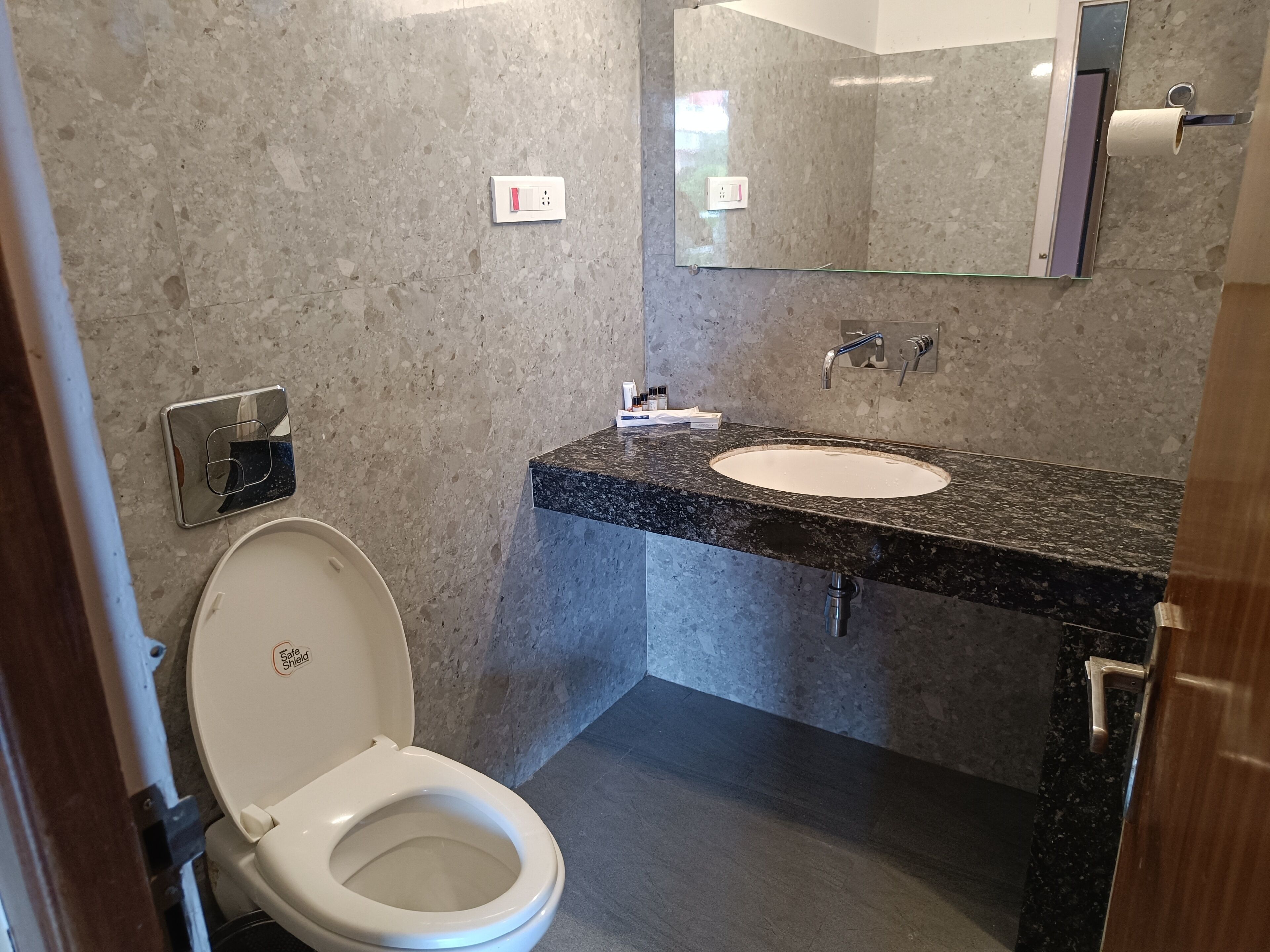 Un bagno con il water, un lavandino e uno specchio.