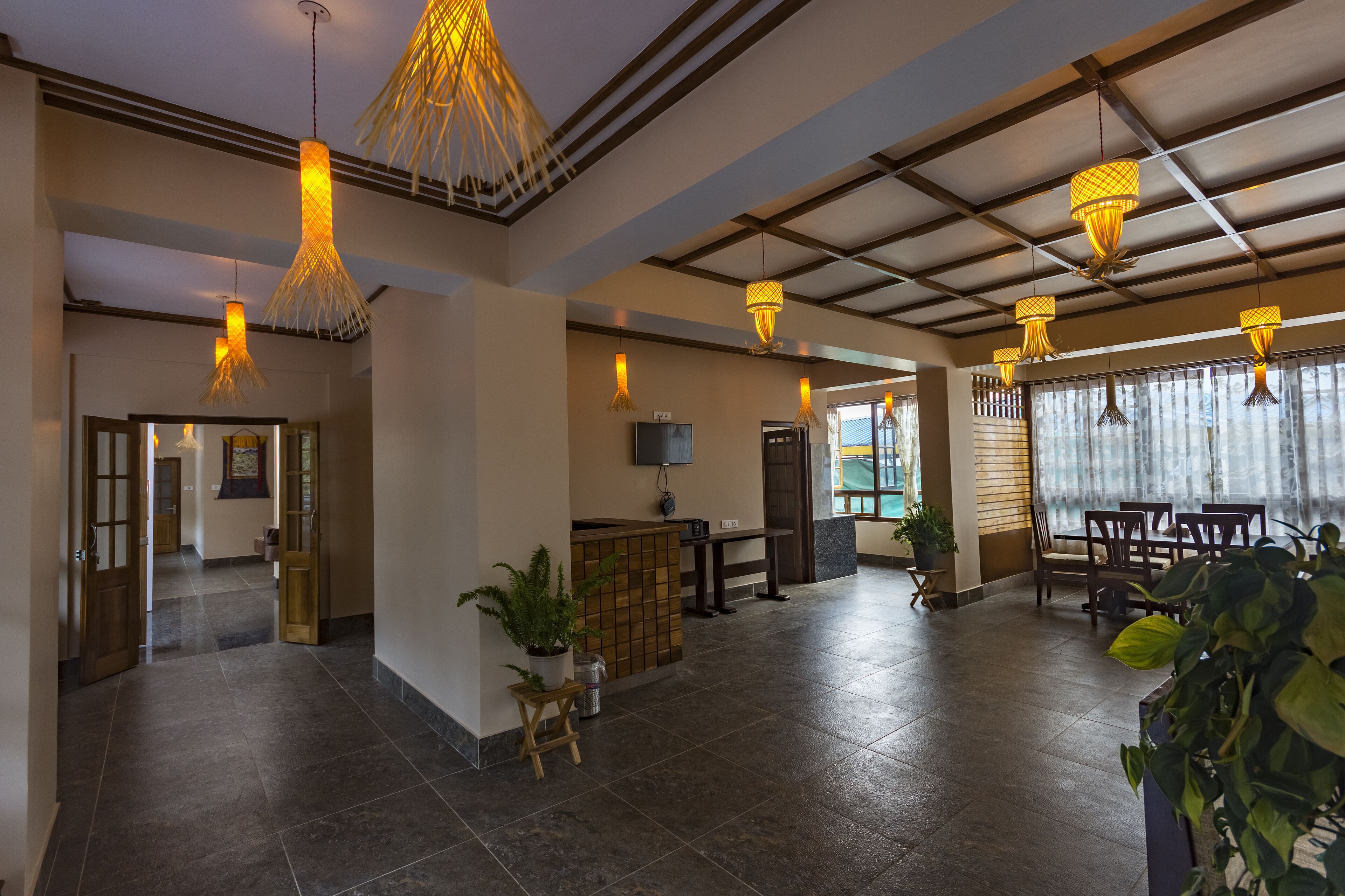 A spacious lobby with a reception desk, seating area, and large windows.