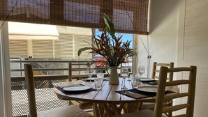 Mesa para cuatro servida con sillas, una planta en maceta y vistas al exterior.