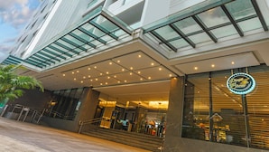 A modern building with a glass facade, a visible entrance, and a sign for "Pizza Brew." - The Plaza Lodge Baguio (Baguio)