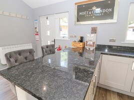 Una cocina moderna con encimera de granito, un sillón tapizado y un cartel anunciando champán Moët & Chandon.