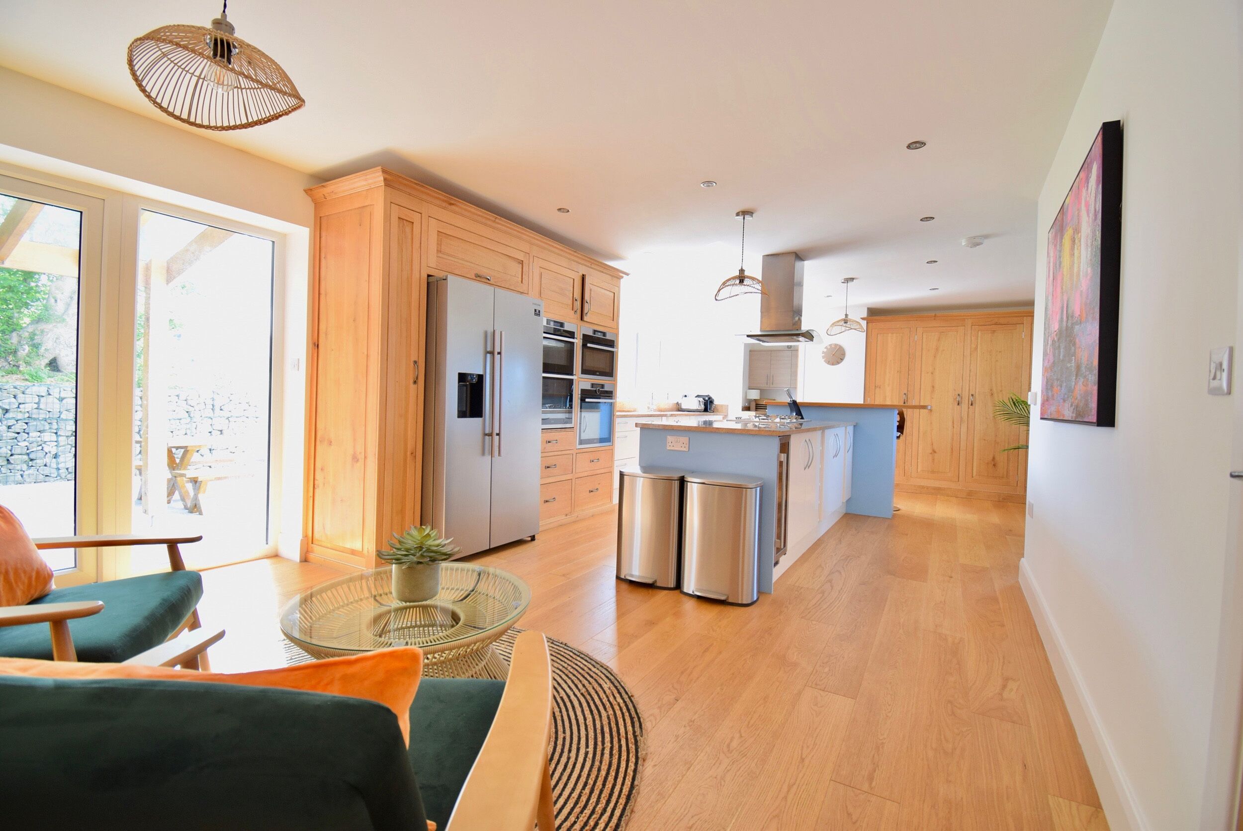 Een moderne keuken met houten kastjes, roestvrijstalen apparatuur en een centraal kookeiland.