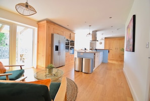 Una cocina moderna con armarios de madera, electrodomésticos de acero inoxidable y una isla central.