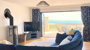 A living room with a TV, sofa, and a fireplace. - Ty Ni (New Quay)