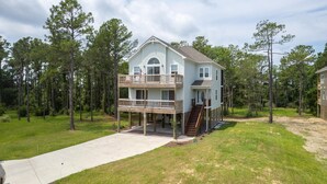 A two-story house with a balcony, a front porch, and a small deck. - OBX Ridgeview 4 Bedroom Home at Southridge (Nags Head)