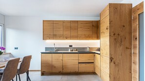 Une cuisine moderne avec des meubles en bois, un plan de travail et un coin repas avec des chaises.