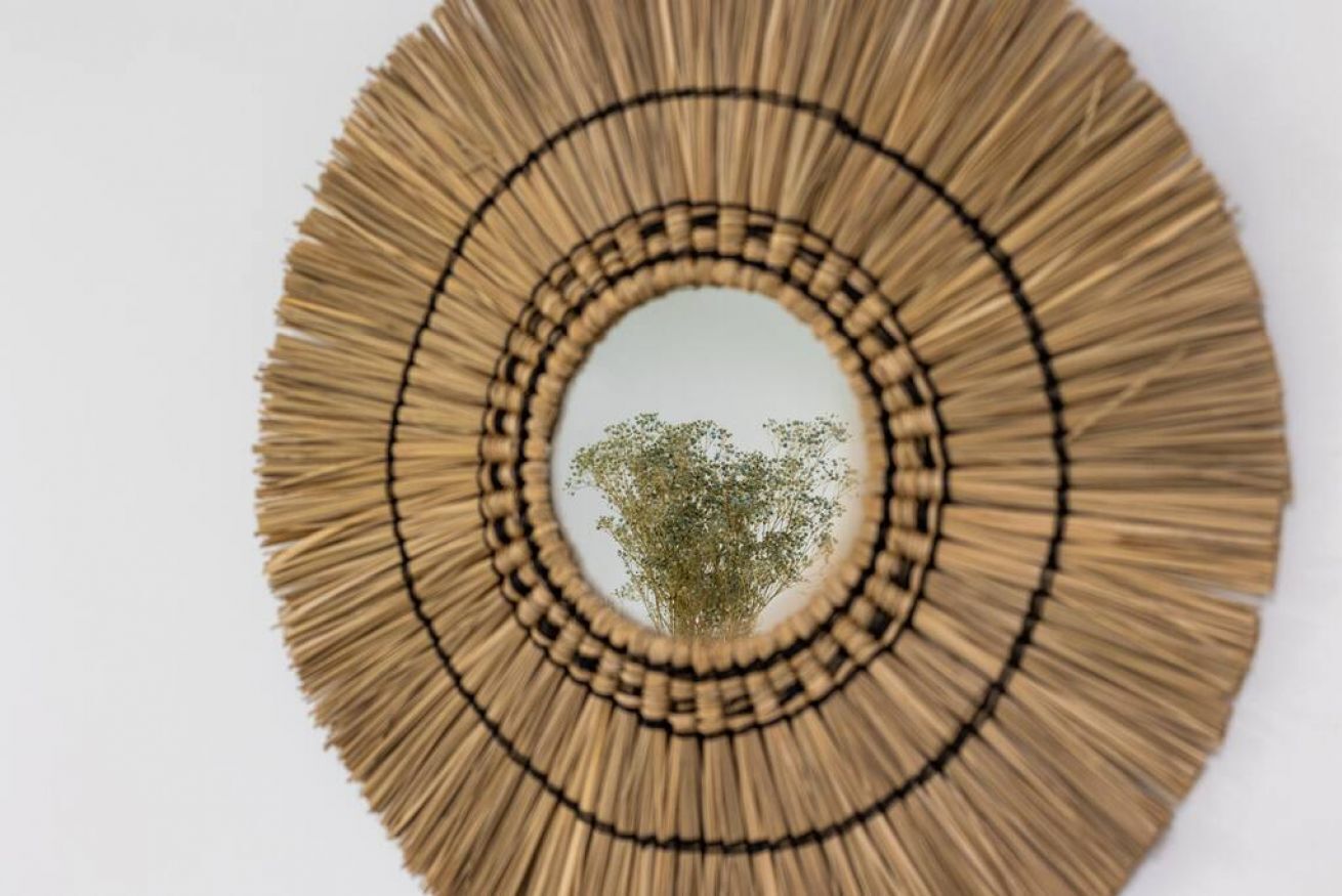 A circular wall hanging with concentric circles of straw-like material.