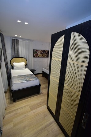 A modern hotel room with a bed, a nightstand, a wall-mounted painting, and a large, decorative door. - Otel Gülayvalık (Ayvalik)