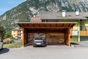 A covered car parking area with a mountain backdrop.