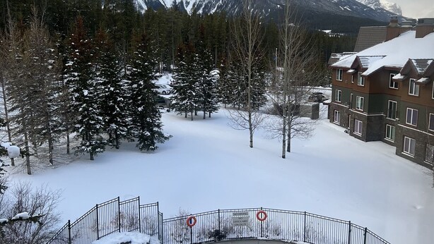 A pool area with a view of snow-covered mountains. - Call to the Wild in Canmore! (Canmore)