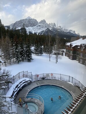 A pool area with a view of snow-covered mountains. - Call to the Wild in Canmore! (Canmore)