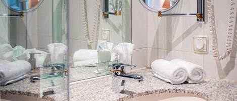 A bathroom with two sinks, mirrors, and a towel rack.