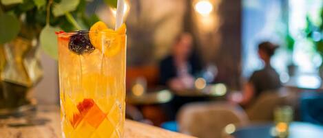 A glass of orange juice with a straw and a slice of lime on a marble table in a restaurant.