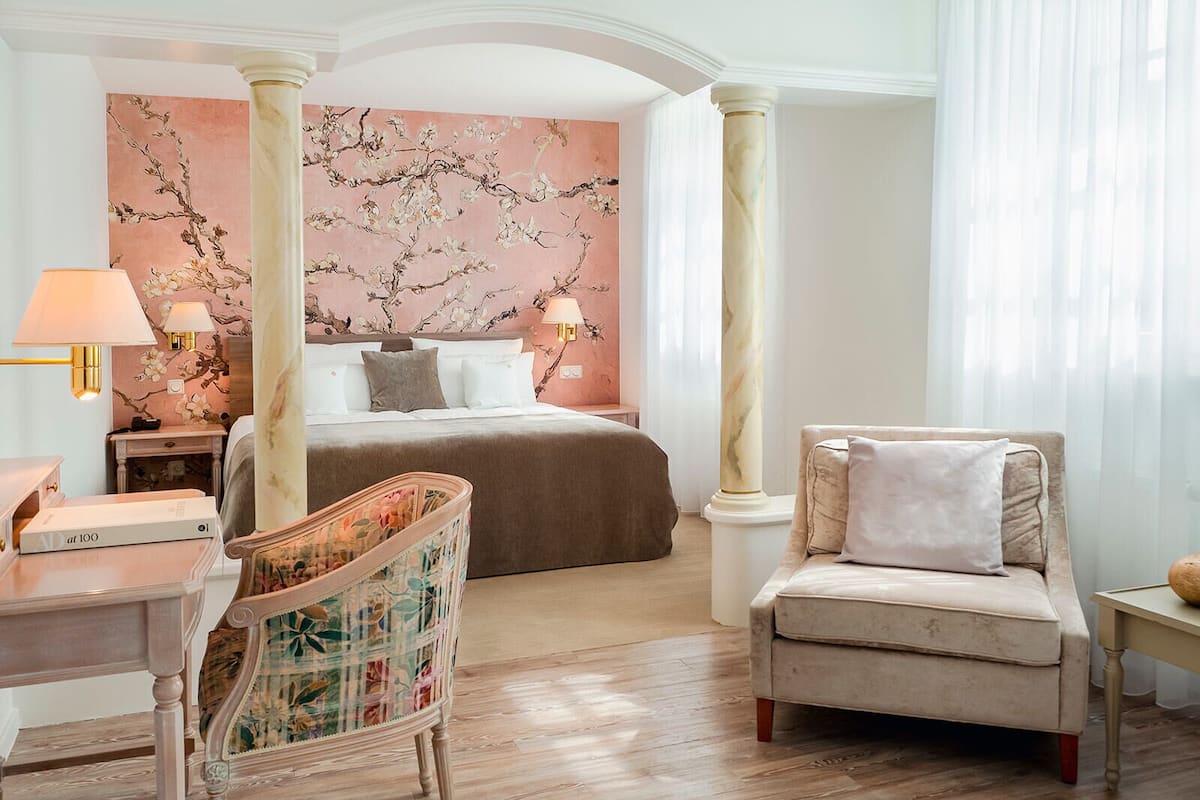 Een hotelkamer met een bed, twee nachtkastjes, een stoel en een bureau.