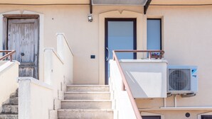 A building with a staircase, a door, and an air conditioning unit. - Apartment Le Primule, pet-friendly, with sea view and balcony (Agrigento)